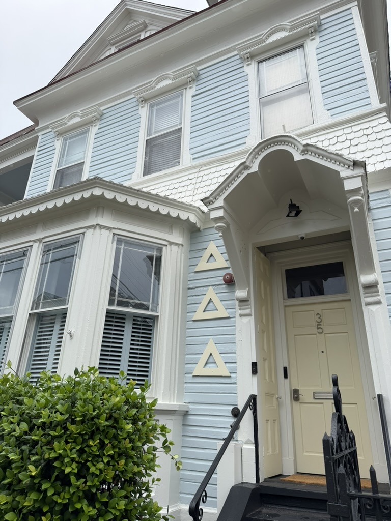 Historic light-blue Tri Delta chapter house near the College of Charleston with Delta Delta Delta letters beside the entrance